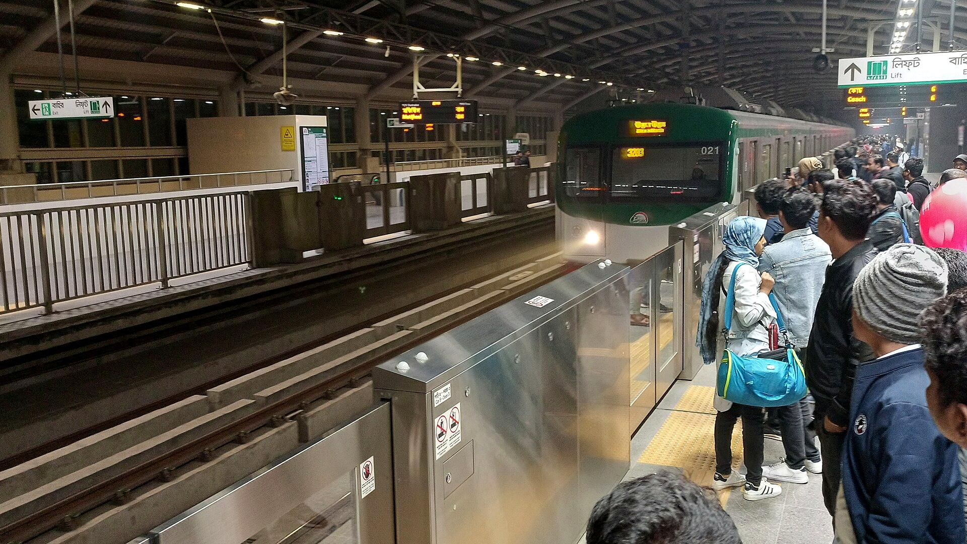 Dhaka Metro Rail train arriving at a crowded platform at night